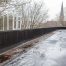 Accumulation d’eau et de débris le long d’un parapet sur un toit plat, près de panneaux solaires installés sur la toiture