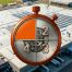 Aerial view of a large commercial flat roof with a stopwatch numbered 1 to 4, highlighting warning signs for roof refurbishment.