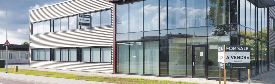 Immeuble commercial moderne affiché à vendre, illustrant l’impact d’une toiture commerciale mal entretenue sur la valeur du bâtiment.