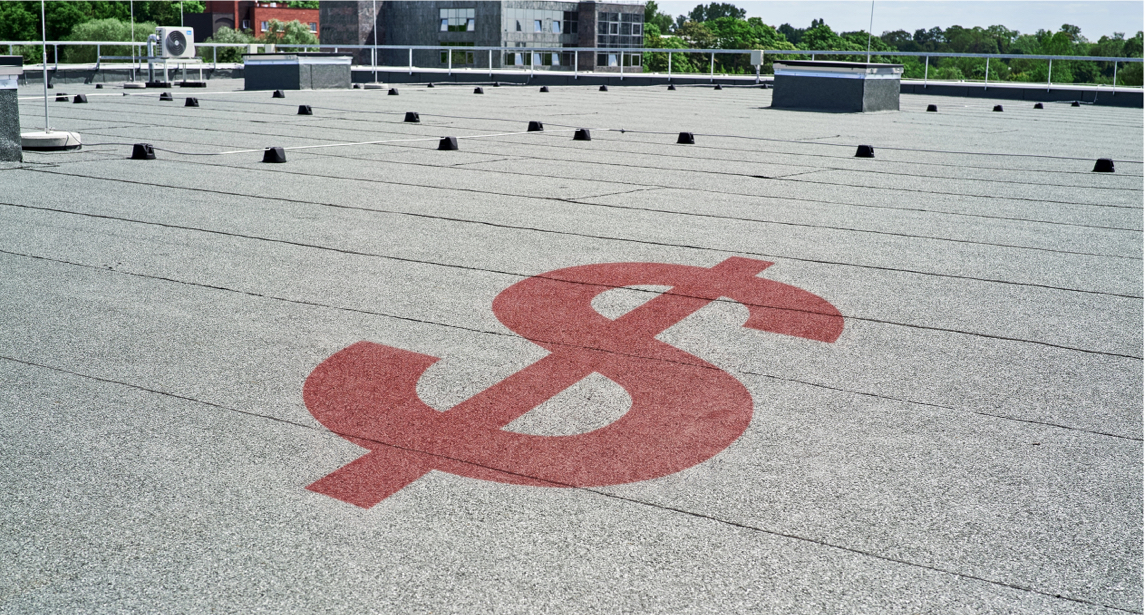 Toiture commerciale à membrane grise avec un symbole de dollar rouge illustrant les coûts liés à un entretien préventif négligé.