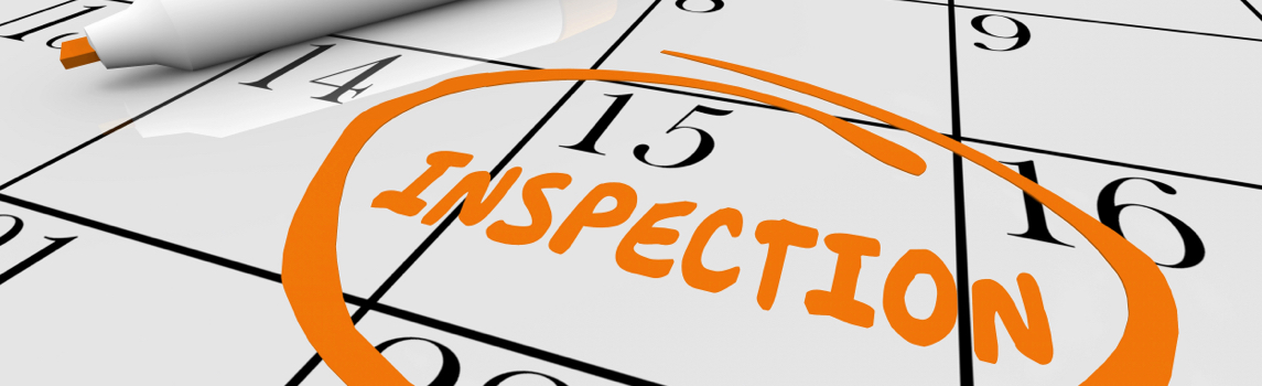 Calendrier en gros plan avec la date du 15 encerclée et le mot « INSPECTION » écrit en orange pour planifier l’entretien de la toiture.